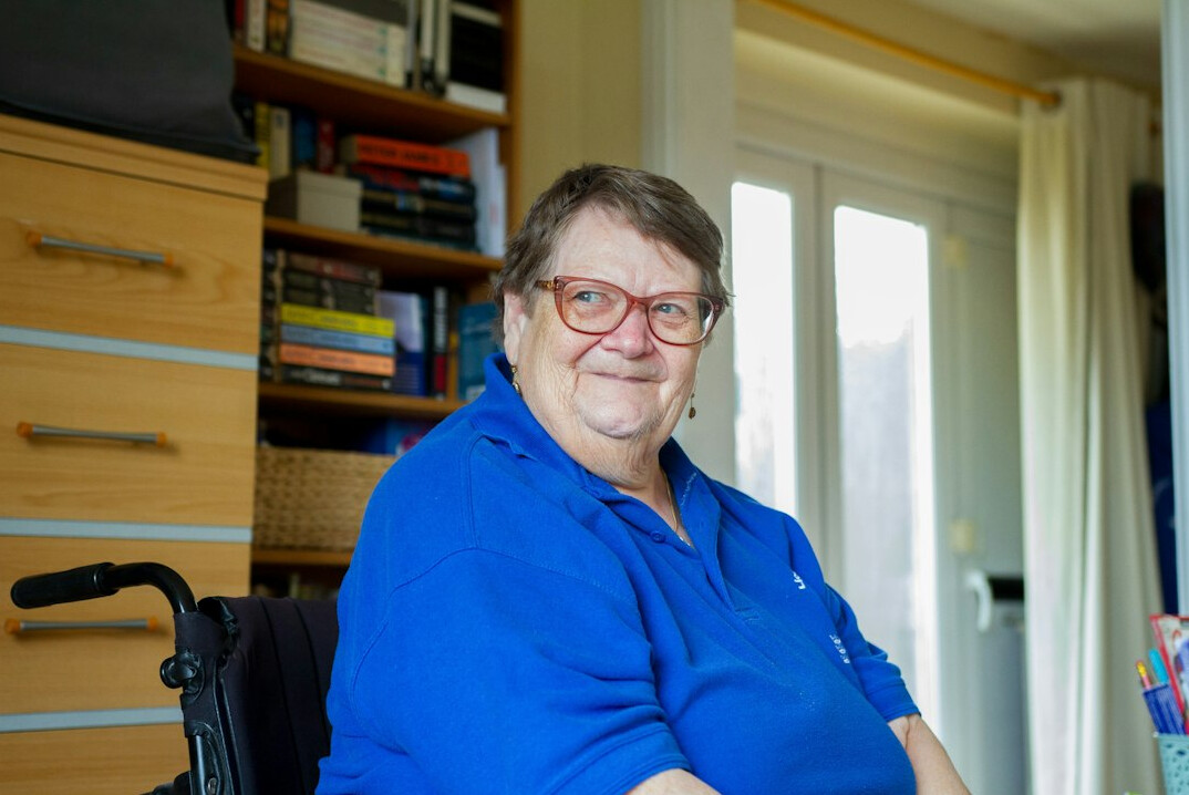 Portrait of a 48 year old woman with brown hair, centre manager, smiling in a bright office