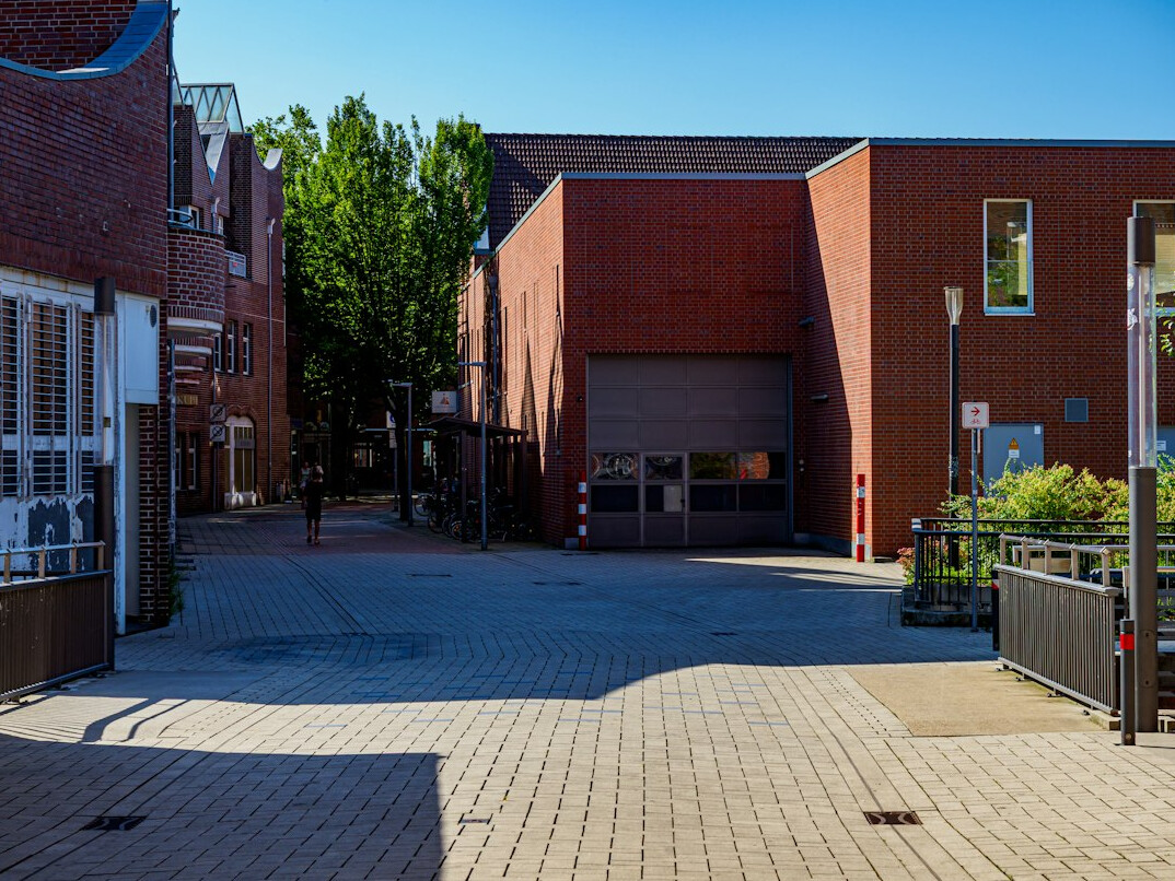 Step-free entrance of a modern community building with a wide ramp and automatic doors